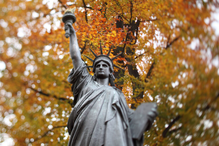 La Estatua de la Libertad en París frente al brillante follaje otoñal.