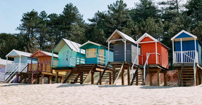 Cabañas de playa coloridas sobre las dunas.