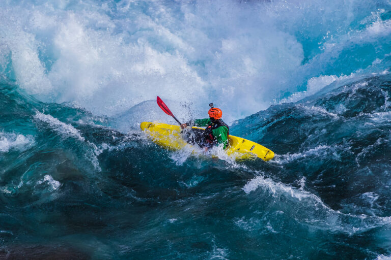 Un kayakista sortea los rápidos de un río turbulento.
