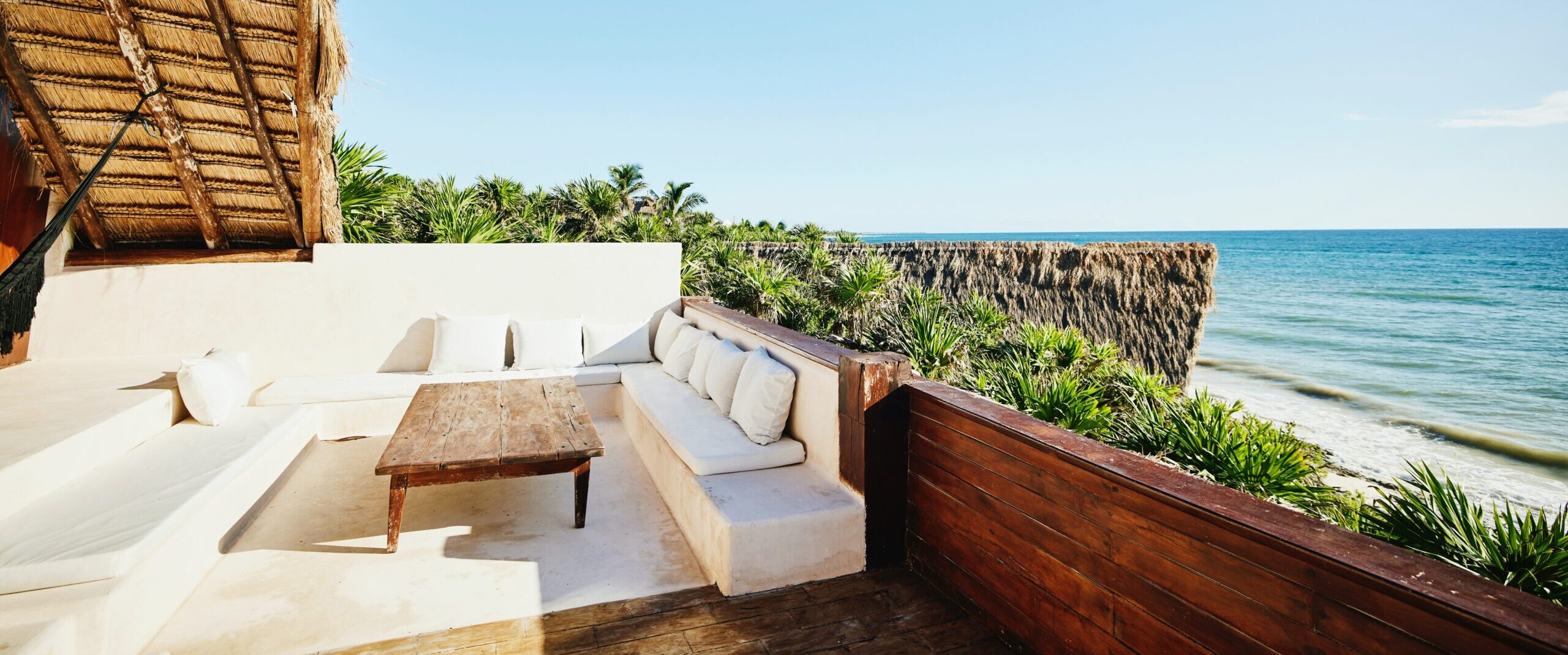 Toma amplia de la zona de asientos en la terraza de una suite de lujo en un complejo turístico tropical