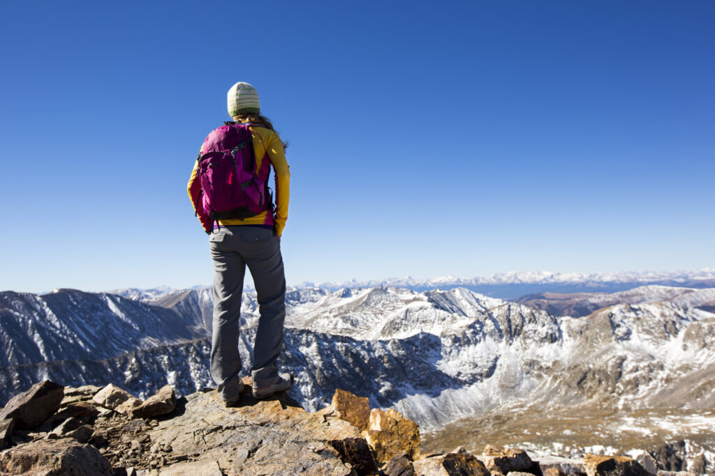Una joven de excursión en la cima de un pico de 14.000 pies cerca de Breckenridge, Colorado.