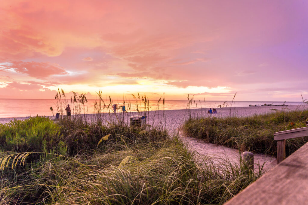 El sol se pone en la playa de Naples, en el Golfo de México, suroeste de Florida, EE. UU. Fantástica puesta de sol a la hora azul en este idílico lugar para vacaciones familiares y relax.